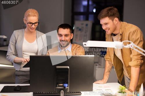 Image of business team with computer working late at office