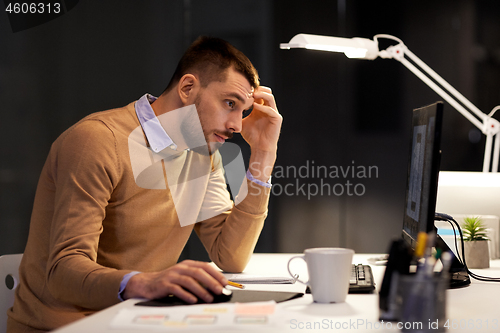 Image of man with computer working late at night office