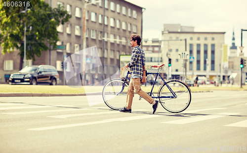 Image of young man with fixed gear bicycle on crosswalk