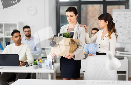 Image of female office worker with box of personal stuff