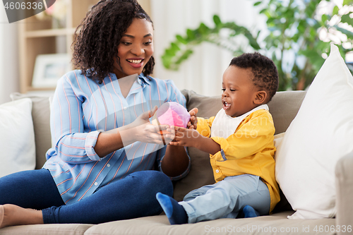 Image of mother and baby playing with ball at home