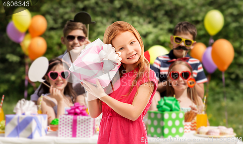 Image of lovely red haired girl with birthday gift at party