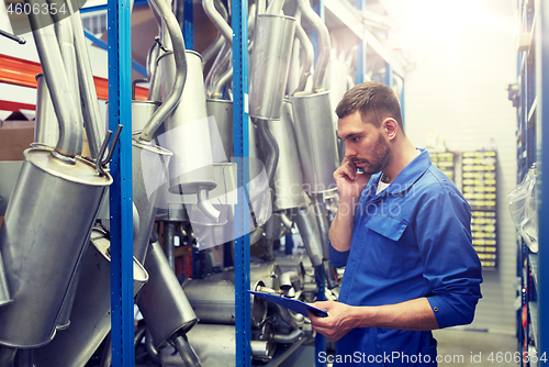 Image of auto mechanic calling on phone at car shop