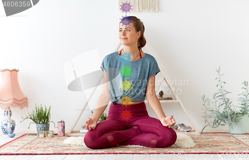 Image of woman meditating in lotus pose at yoga studio