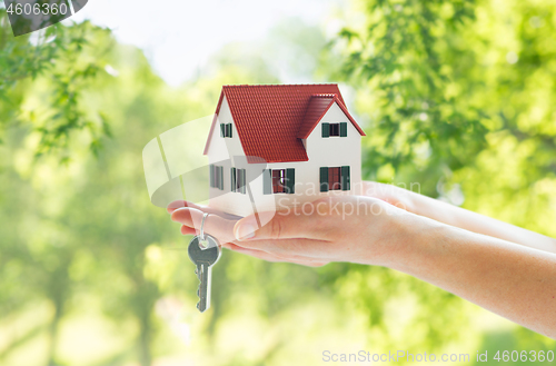 Image of close up of hands holding house model and keys