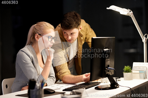 Image of business team with computer at night office