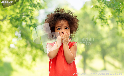 Image of confused african american girl covering mouth