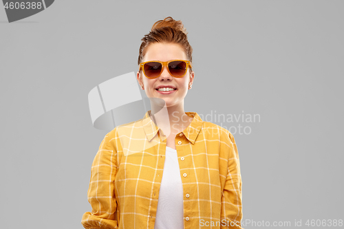 Image of smiling red haired teenage girl in sunglasses