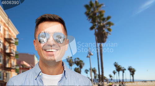 Image of smiling man in sunglasses over venice beach