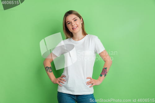 Image of Caucasian young woman\'s portrait on green studio background