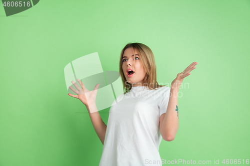 Image of Caucasian young woman\'s portrait on green studio background