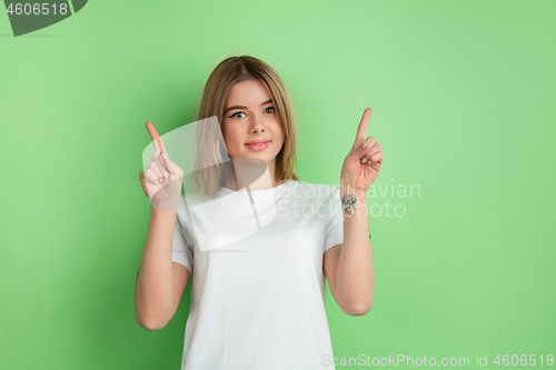 Image of Caucasian young woman\'s portrait on green studio background