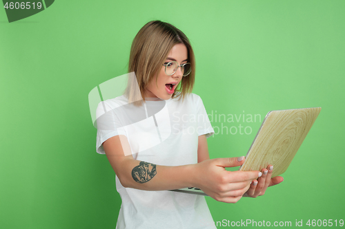 Image of Caucasian young woman\'s portrait on green studio background