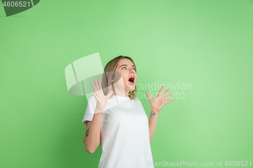 Image of Caucasian young woman\'s portrait on green studio background