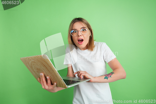 Image of Caucasian young woman\'s portrait on green studio background