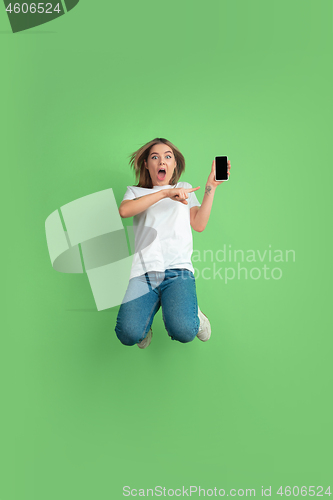 Image of Caucasian young woman\'s portrait on green studio background