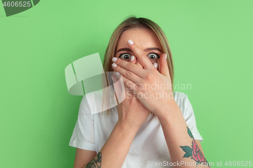 Image of Caucasian young woman\'s portrait on green studio background