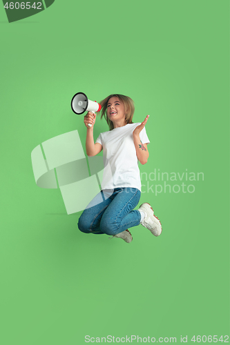 Image of Caucasian young woman\'s portrait on green studio background