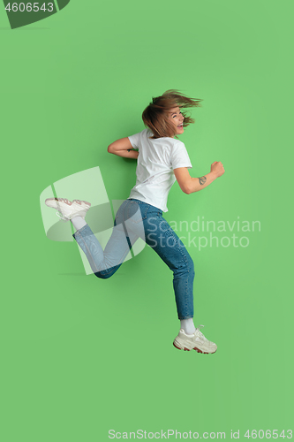 Image of Caucasian young woman\'s portrait on green studio background