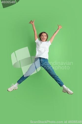 Image of Caucasian young woman\'s portrait on green studio background