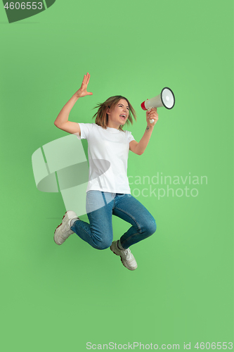 Image of Caucasian young woman\'s portrait on green studio background