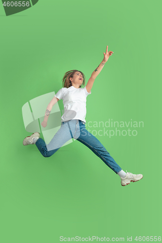 Image of Caucasian young woman\'s portrait on green studio background