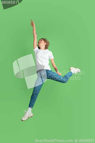 Image of Caucasian young woman\'s portrait on green studio background