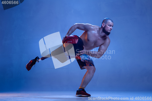 Image of Athlete disabled amputee isolated on blue studio background