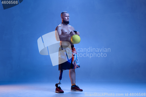 Image of Athlete disabled amputee isolated on blue studio background