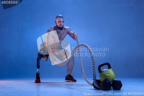 Image of Athlete disabled amputee isolated on blue studio background