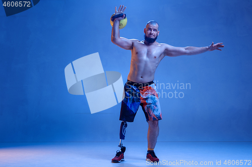 Image of Athlete disabled amputee isolated on blue studio background