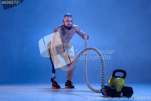 Image of Athlete disabled amputee isolated on blue studio background