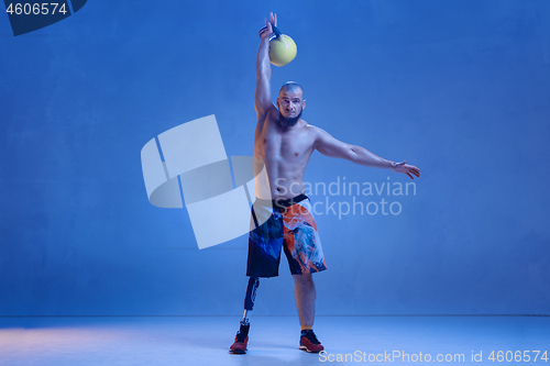 Image of Athlete disabled amputee isolated on blue studio background