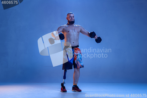 Image of Athlete disabled amputee isolated on blue studio background