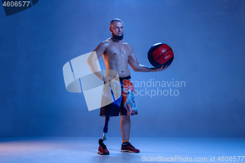 Image of Athlete disabled amputee isolated on blue studio background