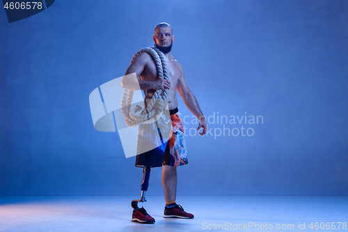 Image of Athlete disabled amputee isolated on blue studio background