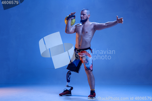 Image of Athlete disabled amputee isolated on blue studio background