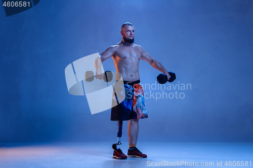 Image of Athlete disabled amputee isolated on blue studio background