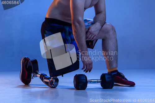 Image of Athlete disabled amputee isolated on blue studio background