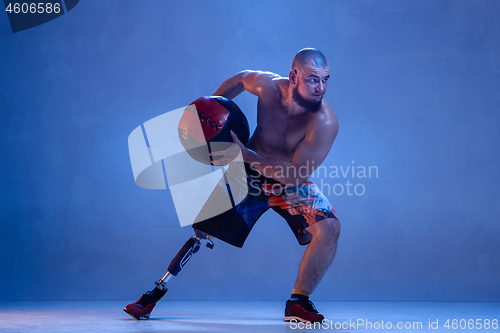 Image of Athlete disabled amputee isolated on blue studio background