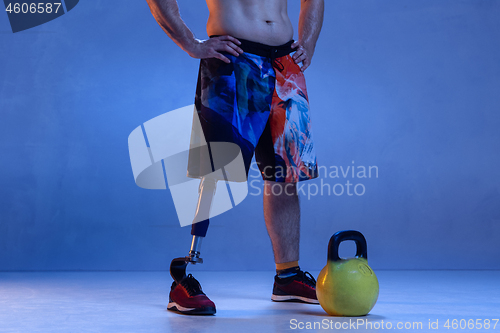 Image of Athlete disabled amputee isolated on blue studio background