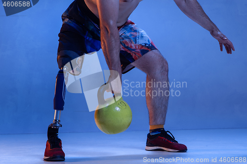 Image of Athlete disabled amputee isolated on blue studio background