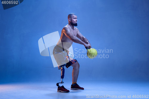 Image of Athlete disabled amputee isolated on blue studio background