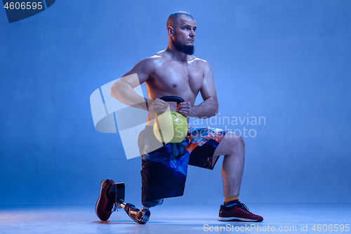 Image of Athlete disabled amputee isolated on blue studio background