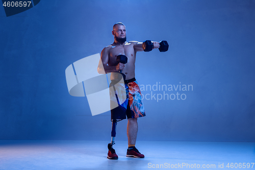 Image of Athlete disabled amputee isolated on blue studio background