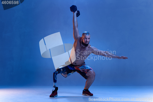 Image of Athlete disabled amputee isolated on blue studio background