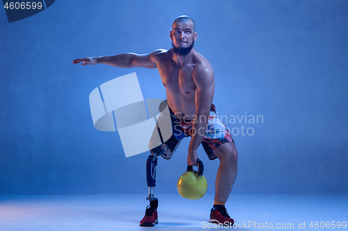 Image of Athlete disabled amputee isolated on blue studio background