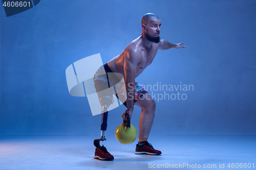 Image of Athlete disabled amputee isolated on blue studio background