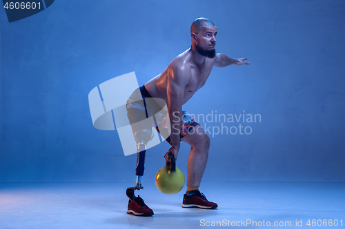 Image of Athlete disabled amputee isolated on blue studio background