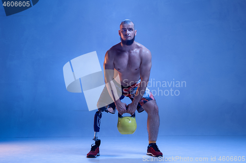 Image of Athlete disabled amputee isolated on blue studio background